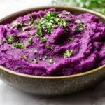Creamy purple mashed potatoes with fresh herbs.
